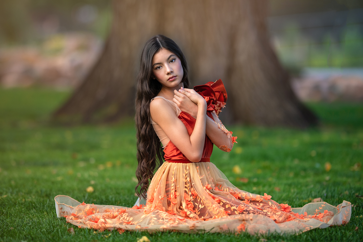 A young girl wearing an orange gown.