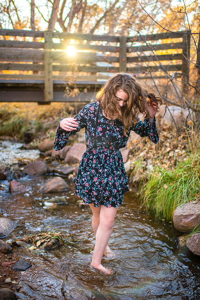 A young woman standing in a stream.