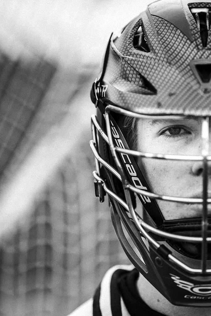 A young man wearing a lacrosse helmet.
